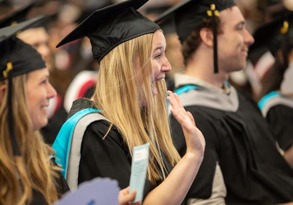 a blonde woman in cap and gown in a group of VIU graduates